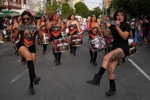 Marcha festiva em Lima com banda de mulheres a tocar tambores e outros instrumentos de percussão