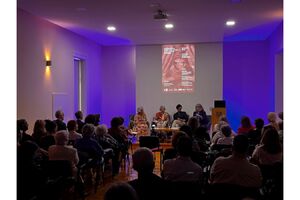 Pessoas participam num evento literário num espaço fechado