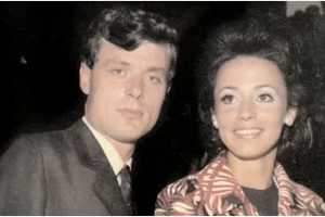 Um homem e uma mulher sorriem para a câmara