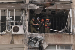 Um oficial do Comando da Frente Interna num apartamento danificado após um ataque iraniano 