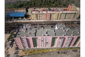 Vista aérea de edifícios coloridos em Lisboa, com tráfego na rua e lixo visível