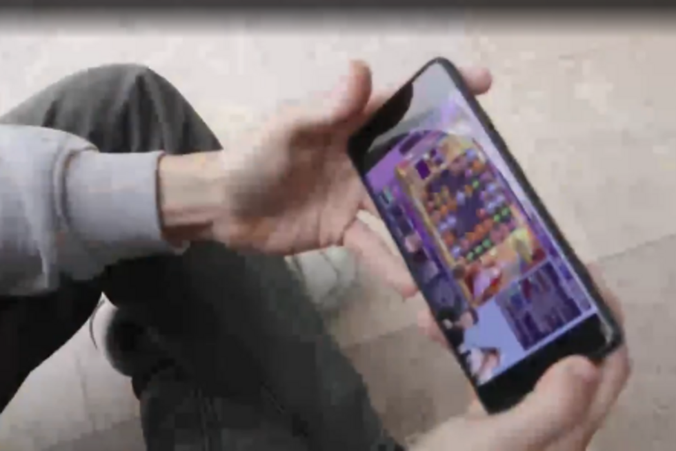 Jogador usa telemóvel com jogo de puzzles colorido