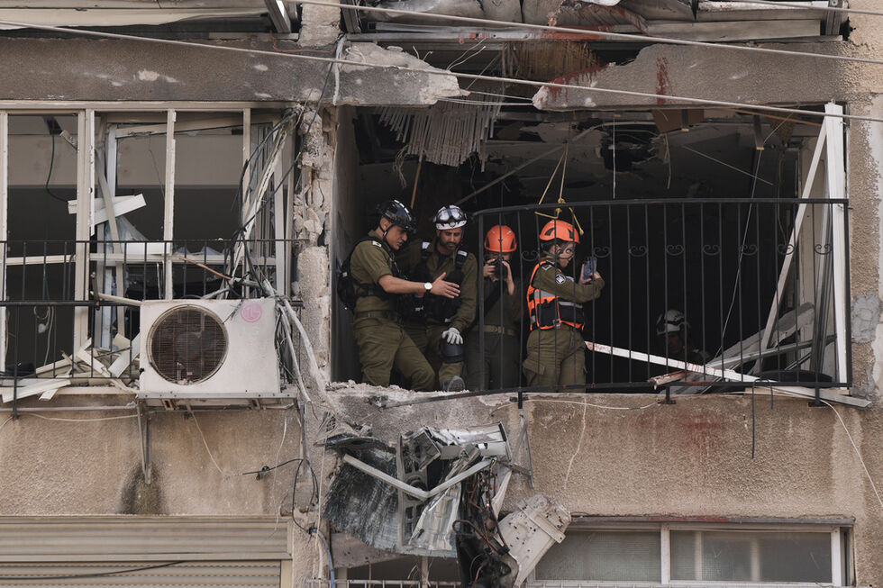 Um oficial do Comando da Frente Interna num apartamento danificado após um ataque iraniano 