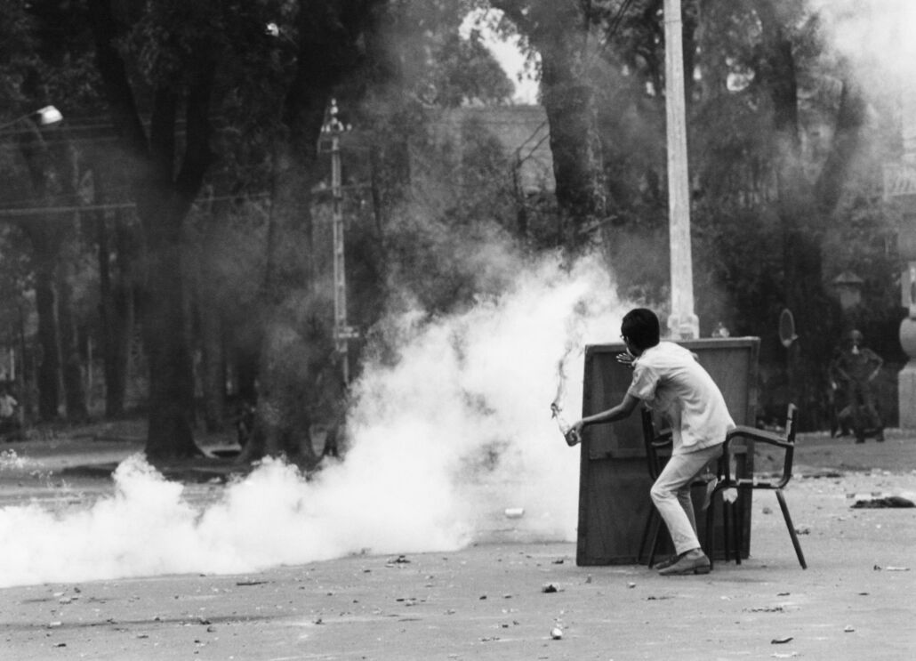 Estudante universitário lança um cocktail molotov contra a polícia durante uma manifestação no Vietname