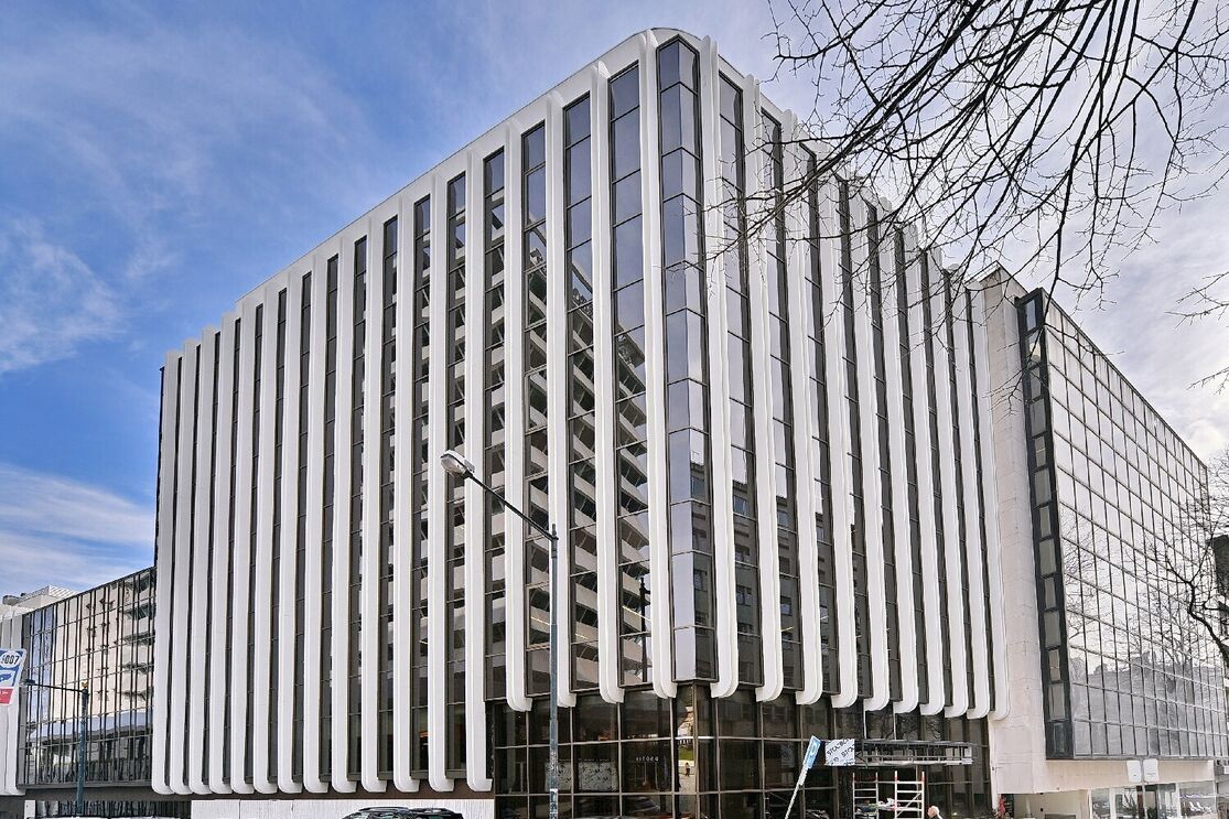 Edifício moderno com fachada em vidro e colunas verticais brancas