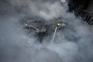 Um bombeiro atira água contra os destroços