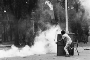 Estudante universitário lança um cocktail molotov contra a polícia durante uma manifestação no Vietname
