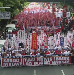 Grupo de pessoas nas Filipinas marcha numa manifestação do Dia do Trabalhador