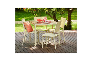 Mobiliário de exterior num deck de madeira com melancia e louça sobre a mesa