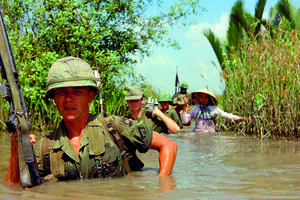 Guerra do Vietname, 1967 - O soldado Fred L. Greenleaf atravessa um canal de irrigação profundo, com outros membros da companhia, durante  a Operação Bang Dong  (21 de novembro de 1967). 