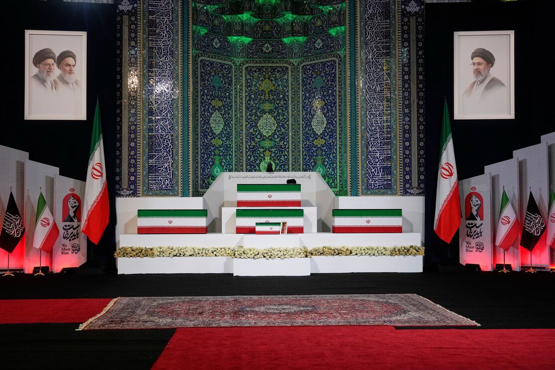 Os caixões de Ali Khamenei, ao centro na parte superior, e de membros da sua família são exibidos antes das cerimónias fúnebres