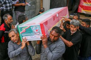 Caixão a ser transportado durante funeral coletivo