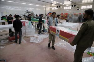Caixões com a bandeira do Irão e fotografias das vítimas 