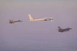 Caça F-16 Fighting Falcon, em primeiro plano, escolta um caça russo Su-35, à esquerda, e um bombardeiro Tu-95 Bear 
