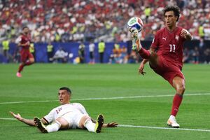 João Félix domina a bola, com Pedro Porro a reclamar falta