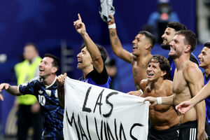 Jogadores de futebol celebram com uma bandeira que diz "Las Malvinas son Argentinas"