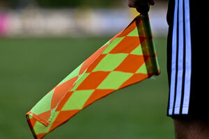 Assistente de arbitragem com bandeira de xadrez laranja e verde