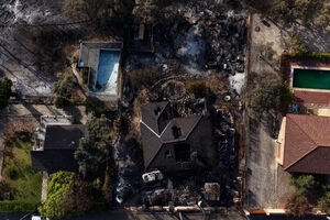 Casas e carros destruídos numa zona florestal fustigada pelo fogo na região de Madrid