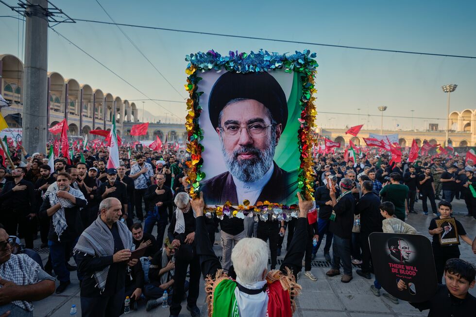 Homem segura foto do novo líder supremo do Irão, Mojtaba Khamenei
