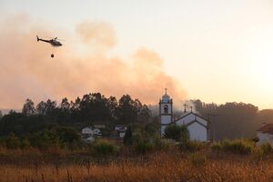Helicóptero efetua descargas aéreas junto de zona de mato perto