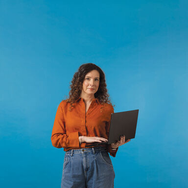 Mulher com computador portátil em fundo azul