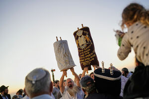 Homens judeus celebram com rolos da Torá em Jerusalém