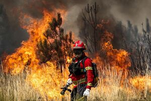 Um bombeiro combate as chamas durante o incêndio em Arganil