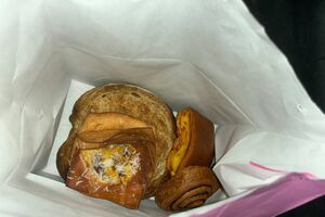 Um saco de pão contém pães doces e um pão redondo