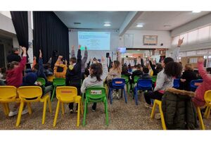 Alunos levantam a mão em sala com tema "Stop Bullying"