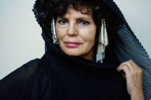 Mulher com vestimenta preta e brincos metálicos, no contexto de exposição de fotografia musical