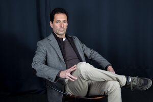 O humorista, sentado, fotografado no estúdio da MediaLivre