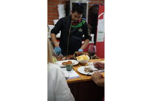 Chef corta leitão para clientes num festival gastronómico