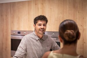 Homem conversa numa cozinha SMEG