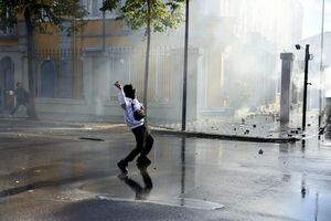 Manifestante atira uma pedra à polícia