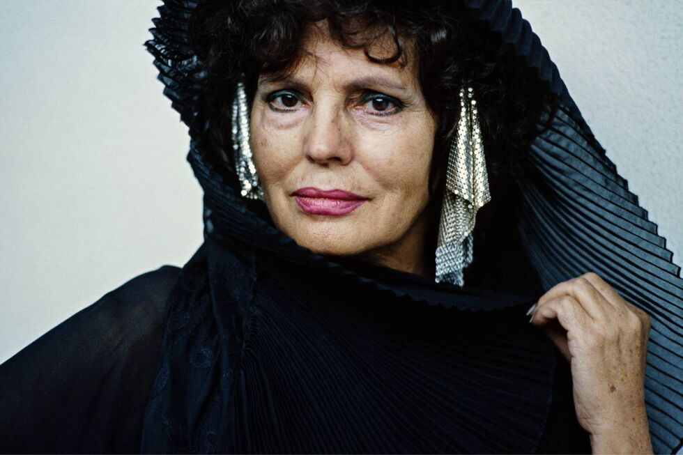 Mulher com vestimenta preta e brincos metálicos, no contexto de exposição de fotografia musical