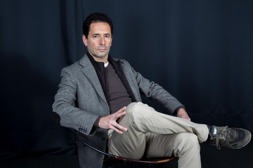 O humorista, sentado, fotografado no estúdio da MediaLivre
